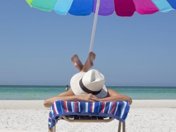Una mujer toma el sol en una playa Una mujer toma el sol en una playa