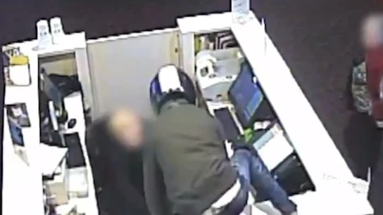 Ladrón robando en un establecimiento de telefonía Ladrón robando en un establecimiento de telefonía