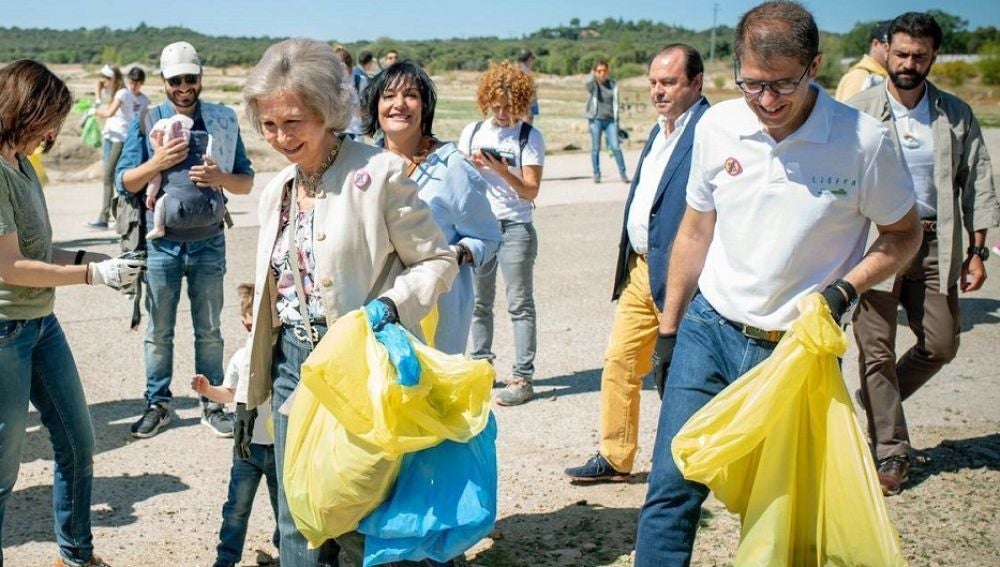 La reina Sofía recogiendo basura en un entorno natural