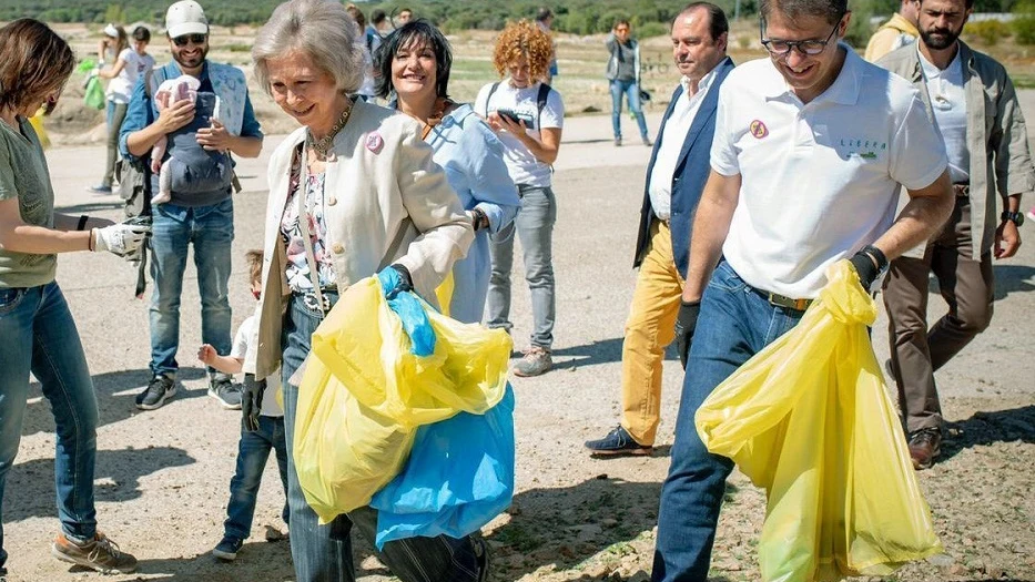 La reina Sofía recogiendo basura en un entorno natural