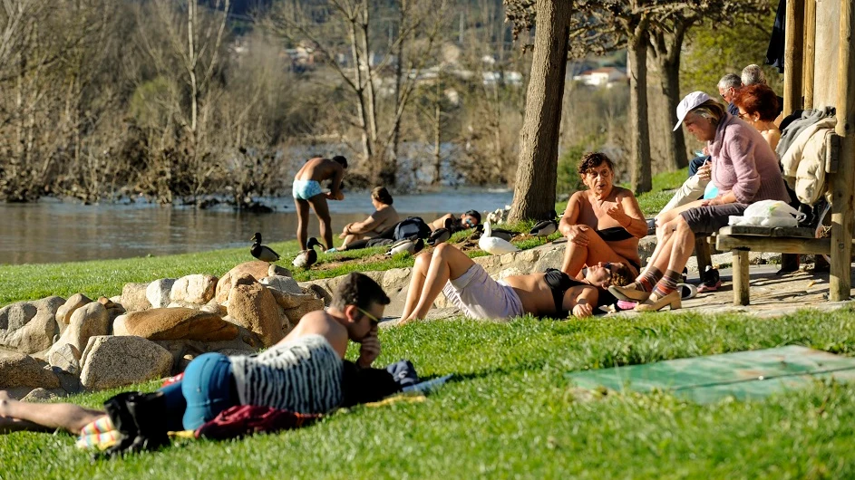 Imagen de archivo de personas tomando el sol en la zona fluvial del río Miño