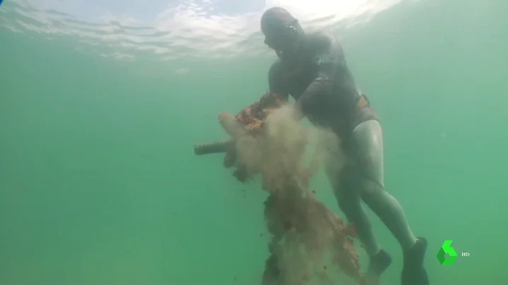 Buzo retirando basura del fondo marino