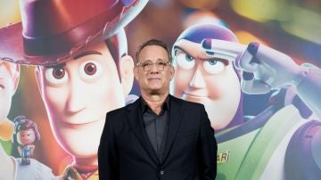 Tom Hanks junto al cartel de presentación de Toy Story
