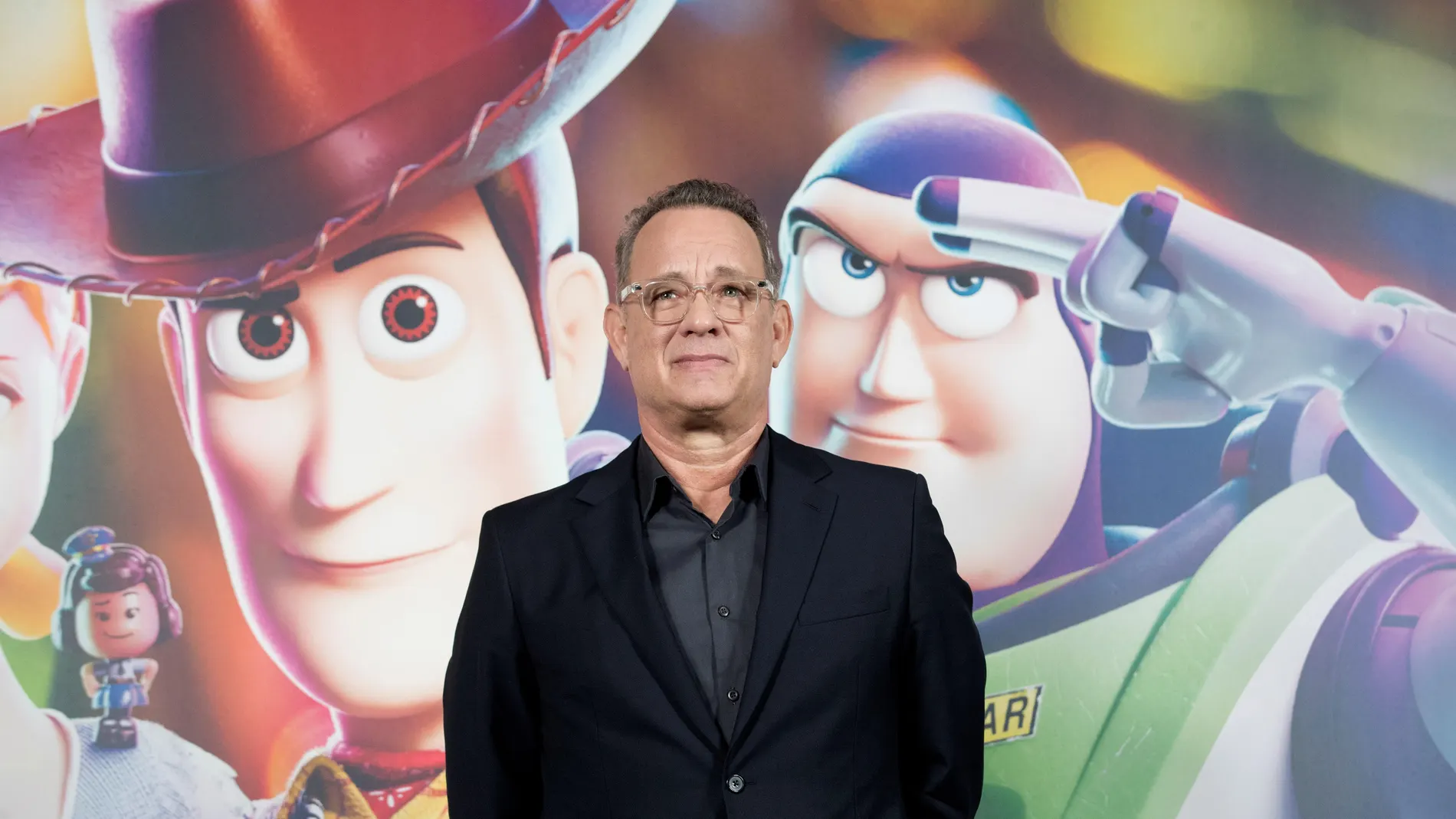 Tom Hanks junto al cartel de presentación de Toy Story