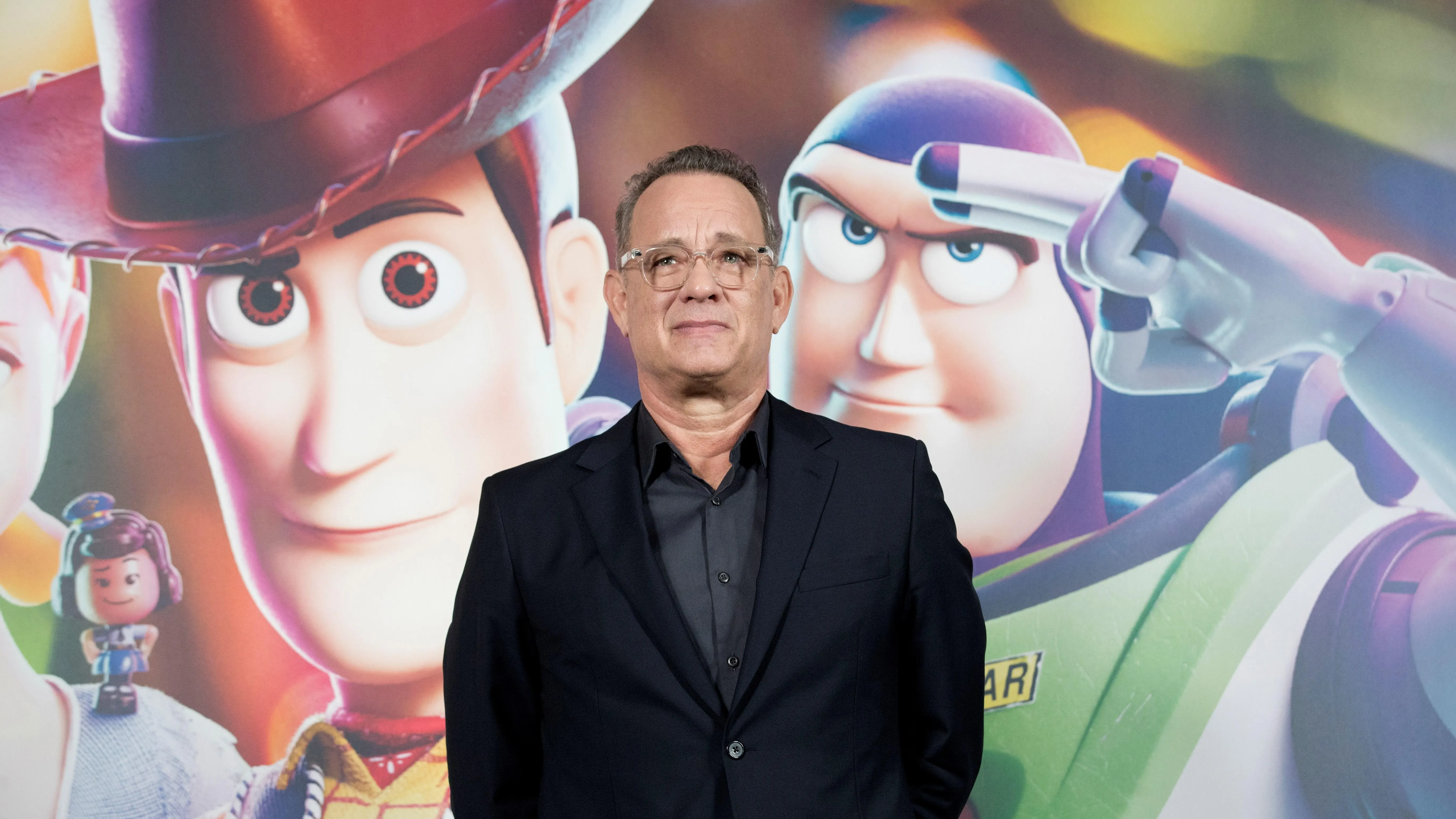 Tom Hanks junto al cartel de presentación de Toy Story