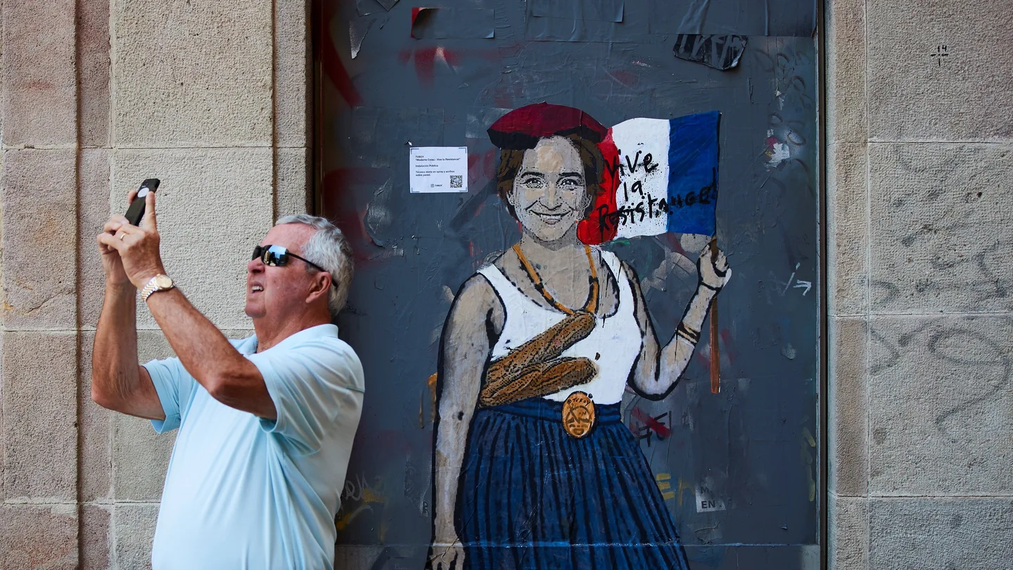 Un señor toma una fotografía junto al grafitti de 'madame Colau' Un señor toma una fotografía junto al grafitti de 'madame Colau'