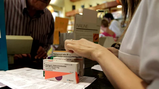 Un hombre adquiere varios medicamentos en una farmacia Un hombre adquiere varios medicamentos en una farmacia