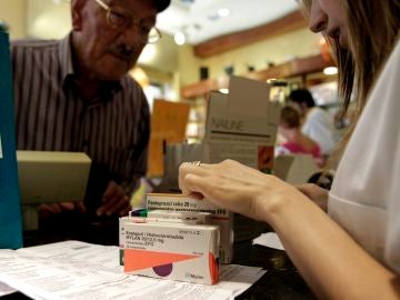 Un hombre adquiere varios medicamentos en una farmacia Un hombre adquiere varios medicamentos en una farmacia