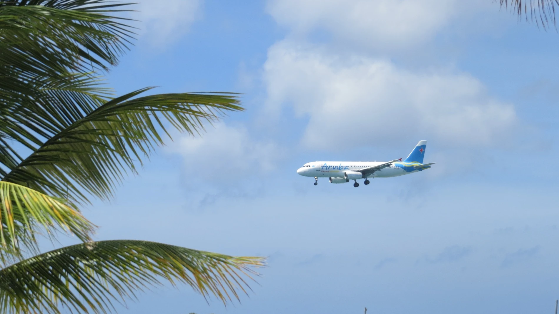 Imagen de un avión volando cerca de una playa.