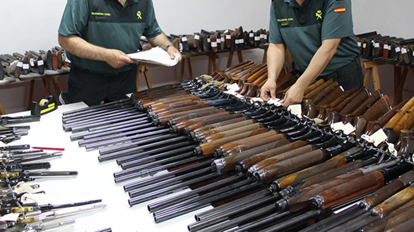 Dos agentes de la Guardia Civil revisan numerosas escopetas y armas Dos agentes de la Guardia Civil revisan numerosas escopetas y armas