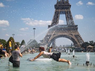Una mujer se refresca con el agua de la fuente de la Plaza del Trocadero Una mujer se refresca con el agua de la fuente de la Plaza del Trocadero