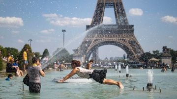 Una mujer se refresca con el agua de la fuente de la Plaza del Trocadero