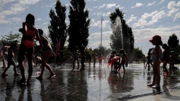 Un grupo de niños se bañan en las fuentes verticales del Madrid Río