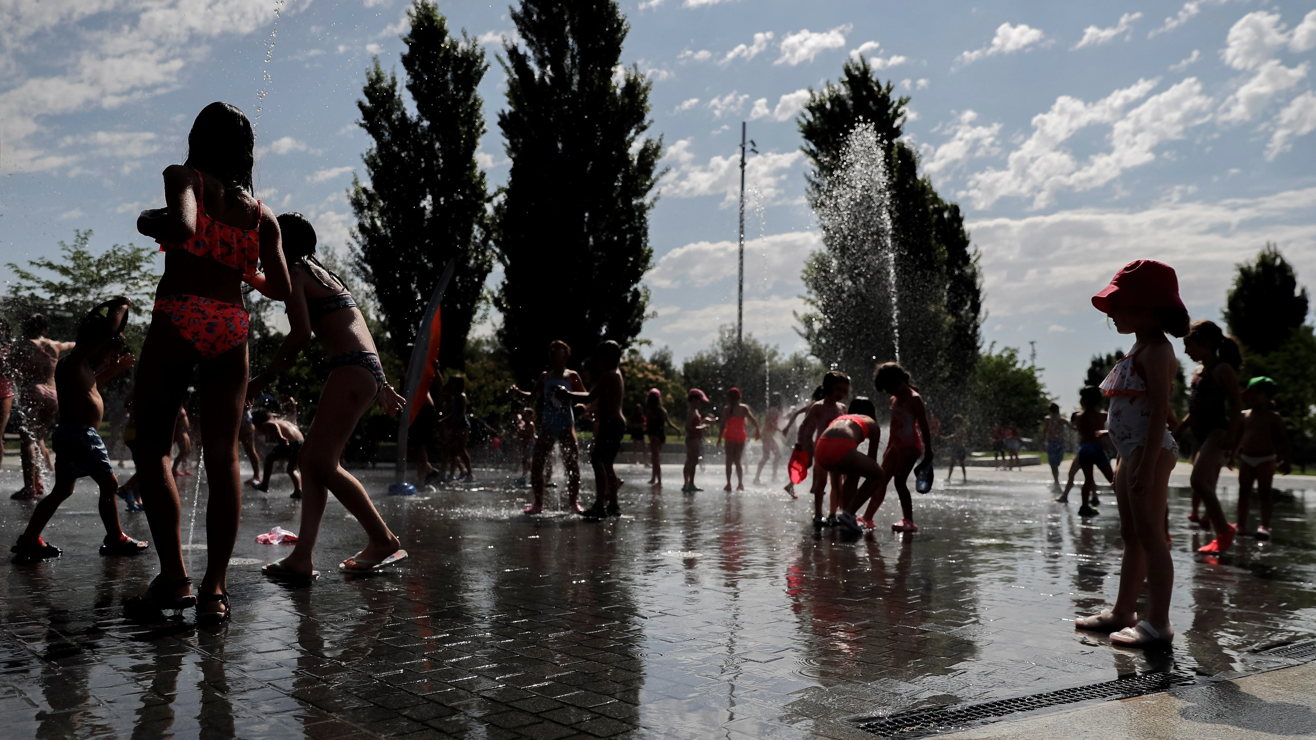 Un grupo de niños se bañan en las fuentes verticales del Madrid Río