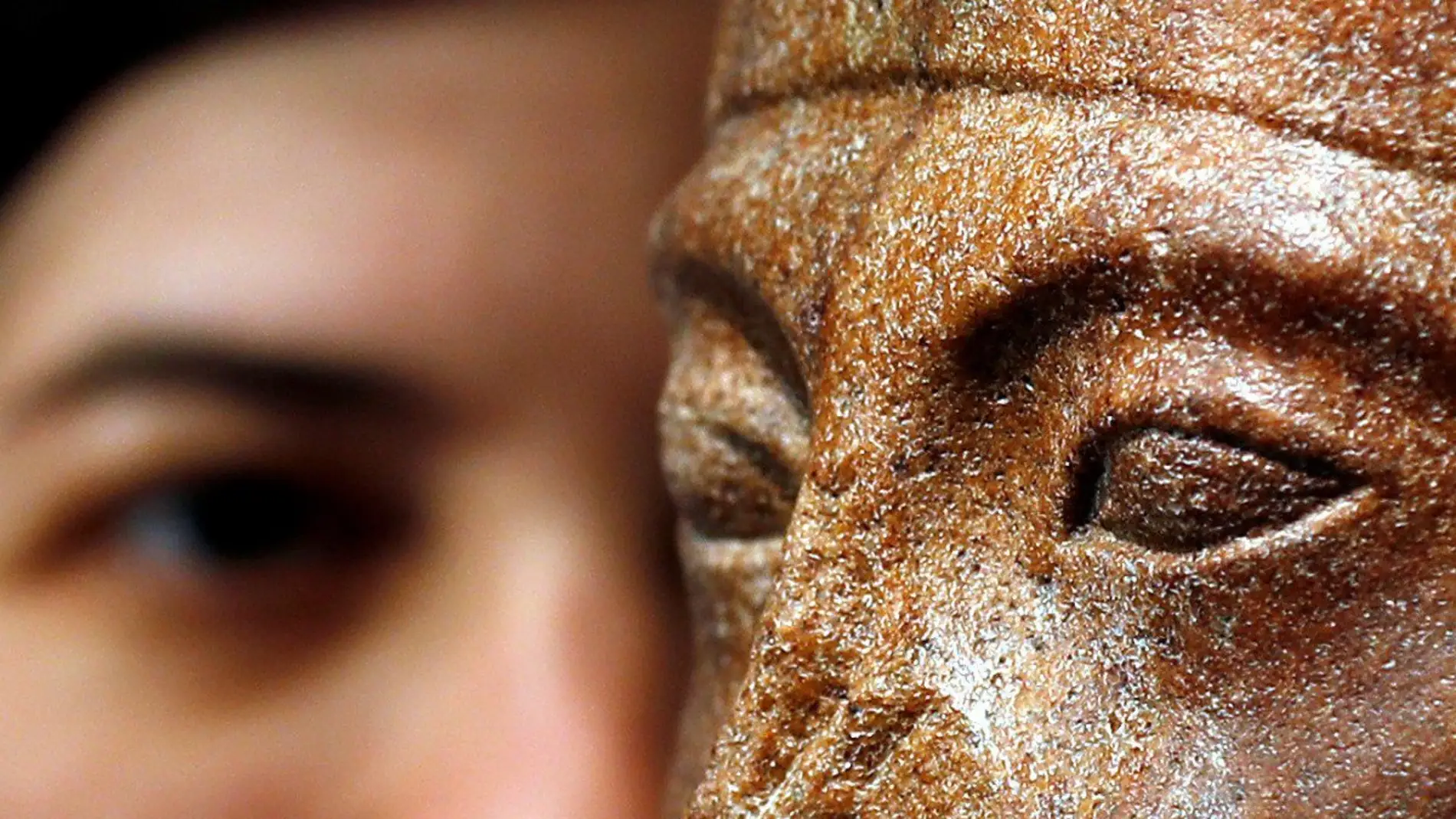 La jefa de antiguedades de Christie's posa junto a una cabeza de cuarcita marrón del joven rey Tutankamón.