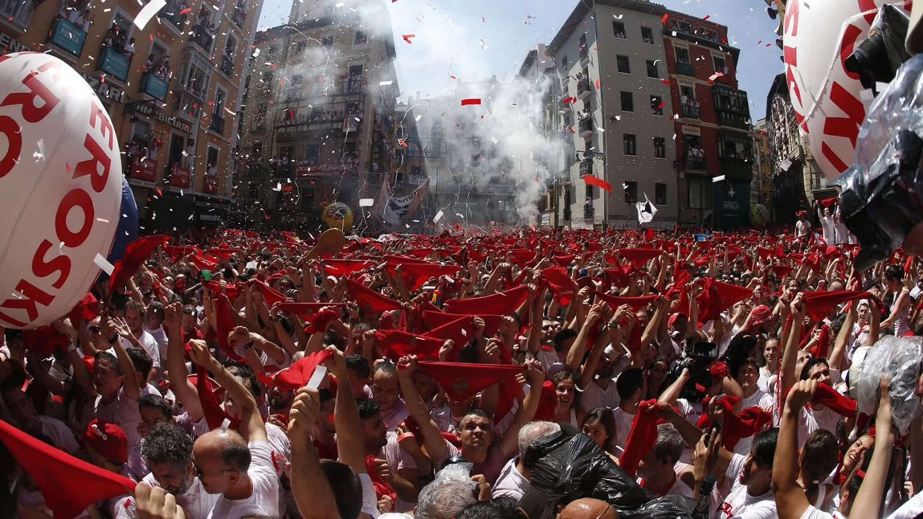Cientos de personas alzan su pañuelo rojo durante el chupinazo de San Fermín en Pamplona.