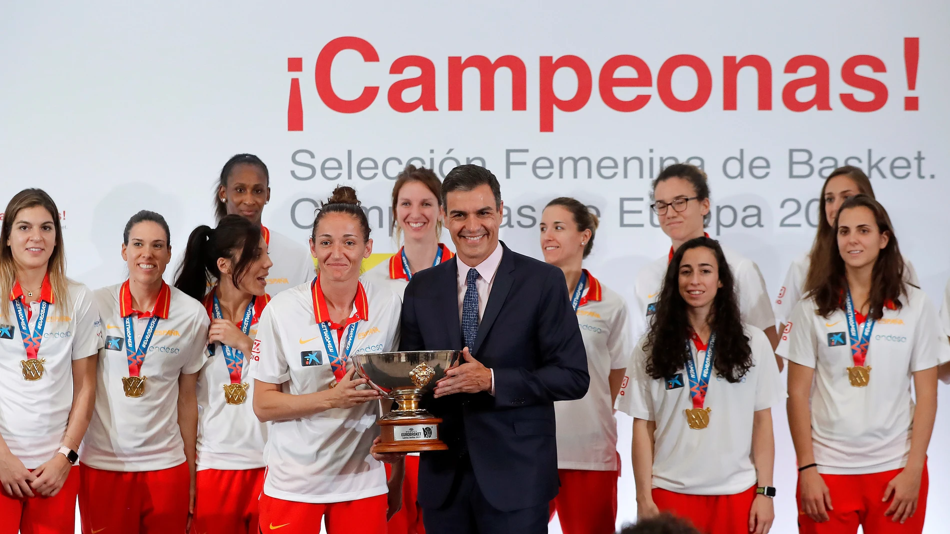 Pedro Sánchez posa con Laia Palau mientras sostienen el trofeo de campeonas del Eurobasket