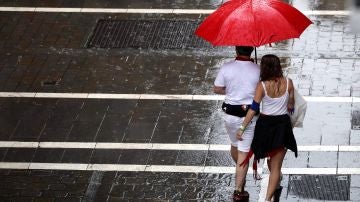 Dos personas se protegen de la lluvia en una de las céntricas calles de Pamplona