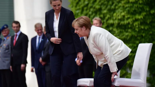 Merkel participa sentada en los honores militares para evitar un nuevo temblor. Merkel participa sentada en los honores militares para evitar un nuevo temblor.