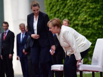 Merkel participa sentada en los honores militares para evitar un nuevo temblor. Merkel participa sentada en los honores militares para evitar un nuevo temblor.