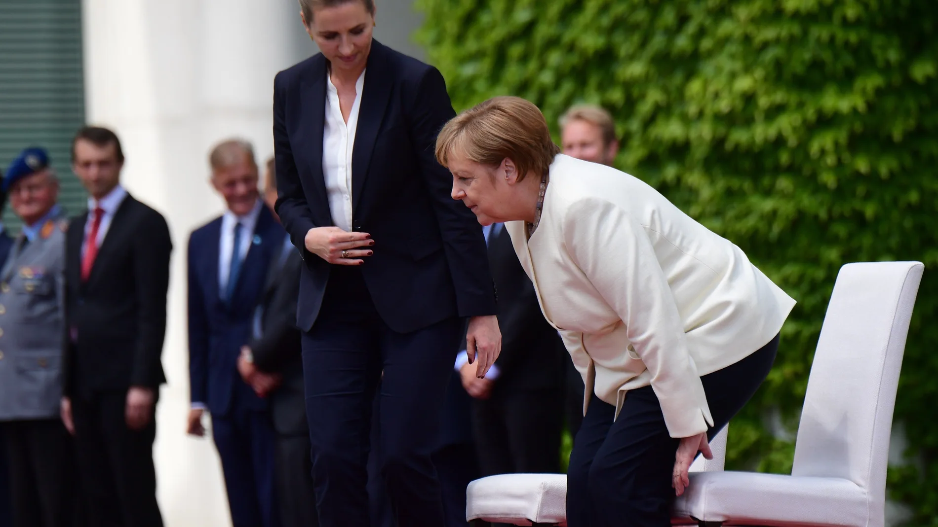 Merkel participa sentada en los honores militares para evitar un nuevo temblor.