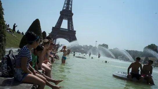 Ciudadanos franceses combaten el calor frente a la Torre Eiffel Ciudadanos franceses combaten el calor frente a la Torre Eiffel