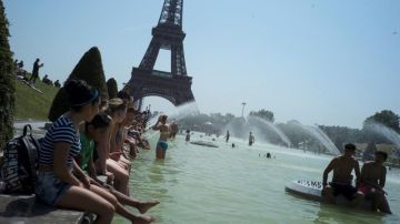 Ciudadanos franceses combaten el calor frente a la Torre Eiffel