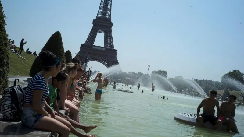 Ciudadanos franceses combaten el calor frente a la Torre Eiffel