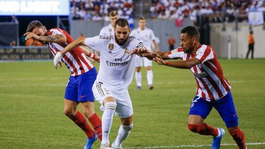 Karim Benzema pelea por el bal&oacute;n durante un partido contra el Atl&eacute;tico de Madrid 