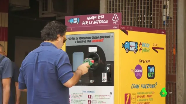 UN hombre tirando una botella de plástico a una máquina en Roma.