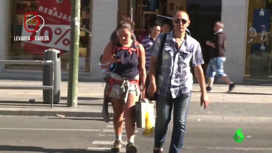 Una mujer utilizando su tel&eacute;fono m&oacute;vil en un paso de peatones.
