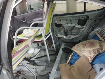 Interior de un vehículo que lleva sillas de playa y una hamaca en lugar de asientos Interior de un vehículo que lleva sillas de playa y una hamaca en lugar de asientos