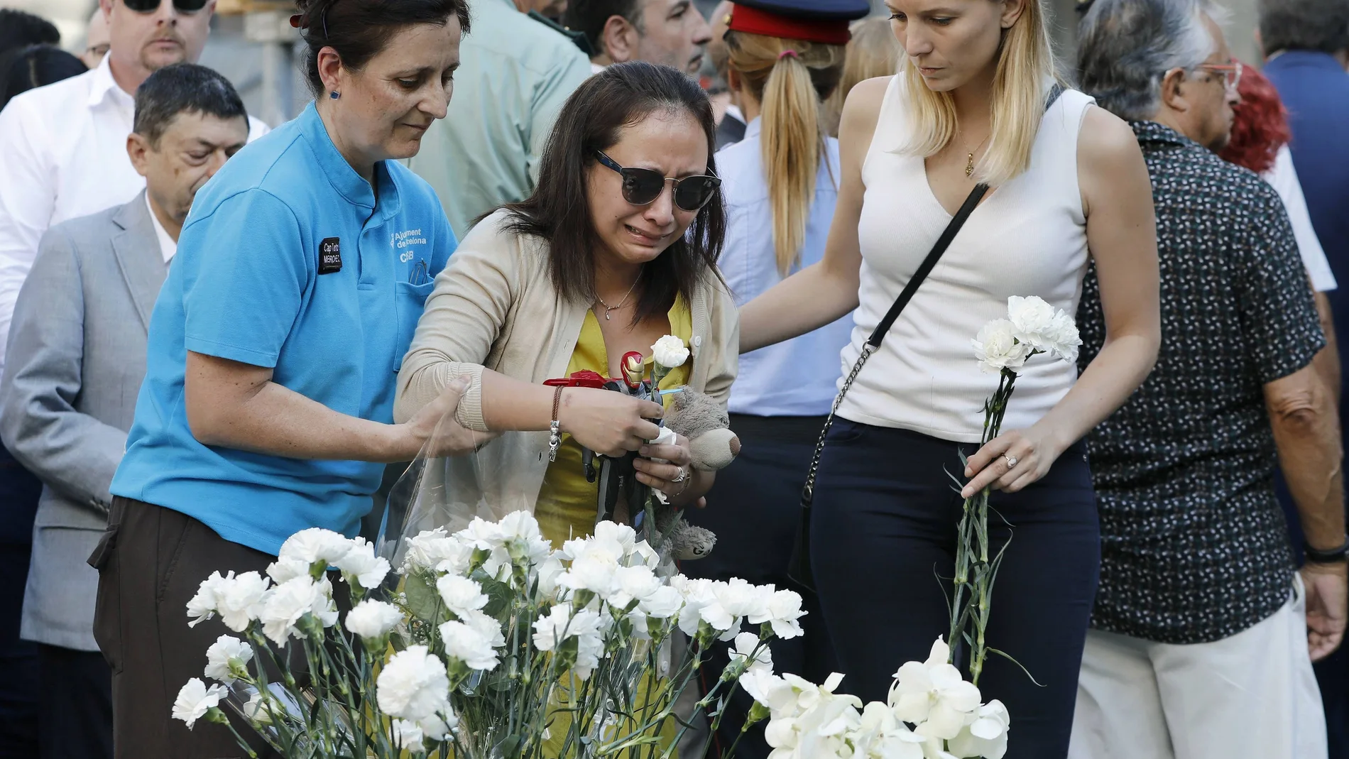Familiares de las víctimas y afectados por el atentado terrorista del 17A depositan claveles blancos durante el acto institucional 
