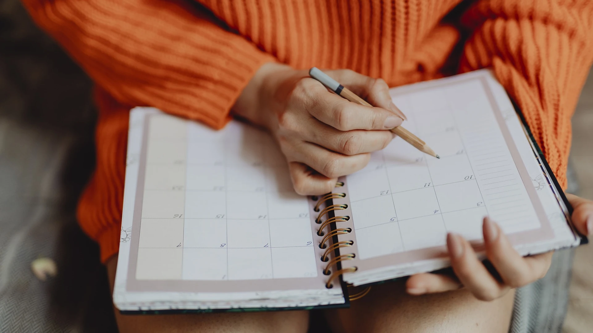 Imagen de archivo de una chica apuntando notas en el calendario de una agenda.