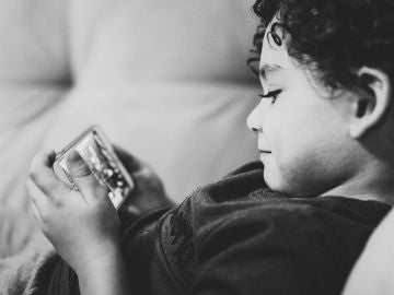 Un ni&ntilde;o con un m&oacute;vil en las manos