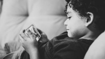 Un niño con un móvil en las manos