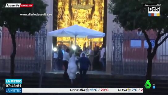 Unos camareros ayudan a una novia a llegar al altar