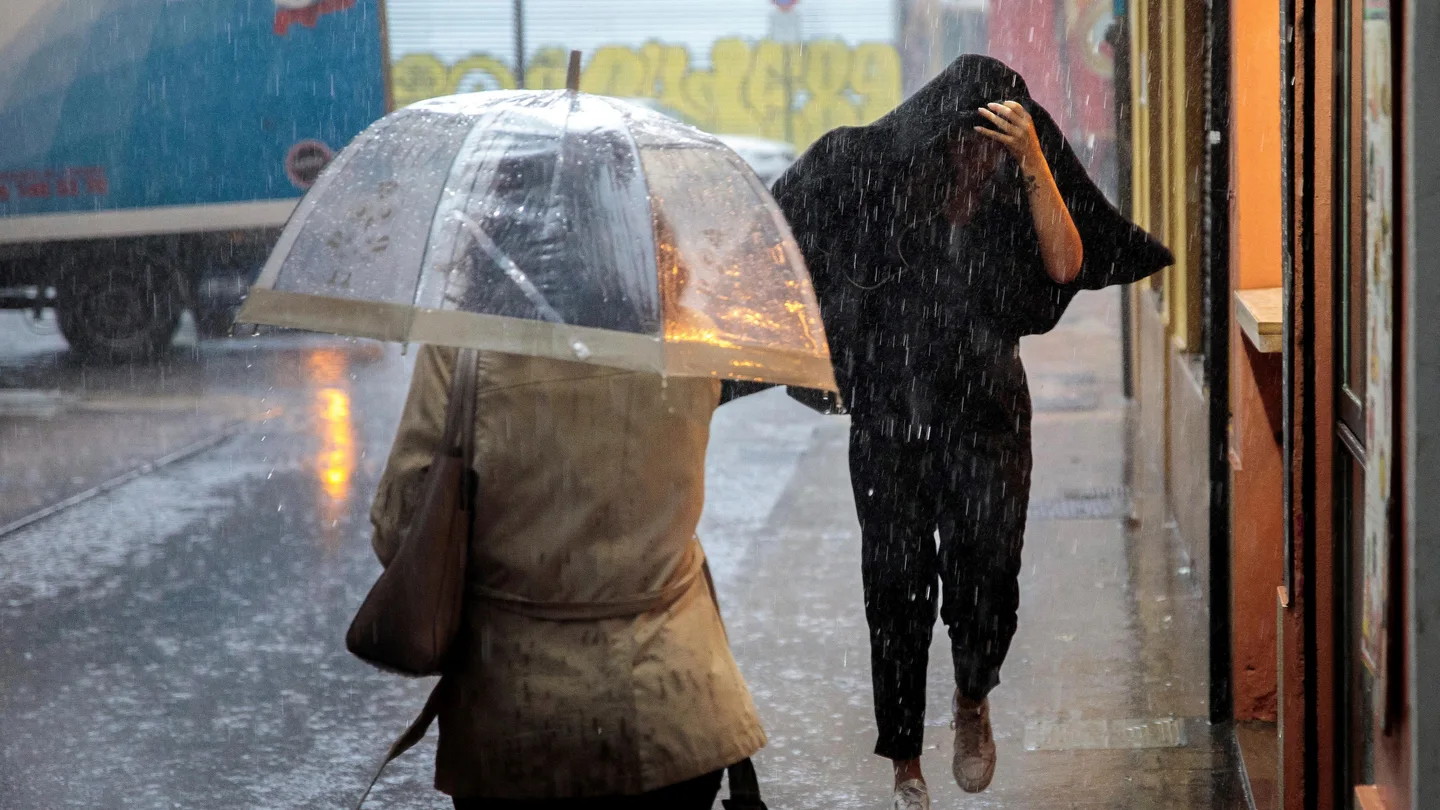 Does personas caminan bajo la lluvia intensa en Valencia Does personas caminan bajo la lluvia intensa en Valencia