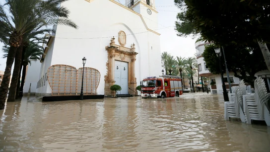 Un camión de bomberos trata de avanzar entre el agua Un camión de bomberos trata de avanzar entre el agua