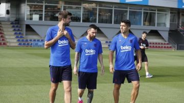 Piqué, Messi y Luis Suárez hablan durante un entrenamiento del FC Barcelona