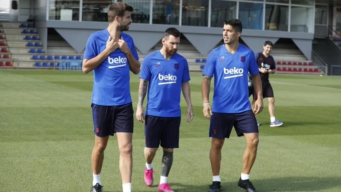 Piqué, Messi y Luis Suárez hablan durante un entrenamiento del FC Barcelona