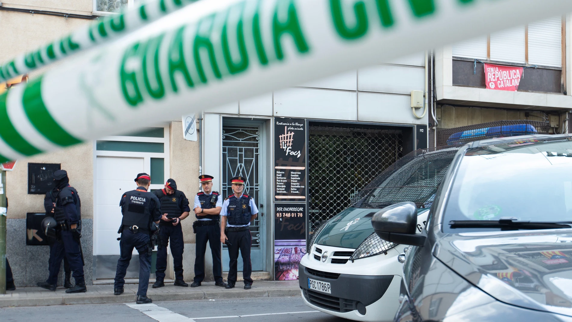 Agentes de la Guardia Civil y Mossos d'Esquadra durante el registro de un domicilio en Sabadell (Barcelona) durante la operación.