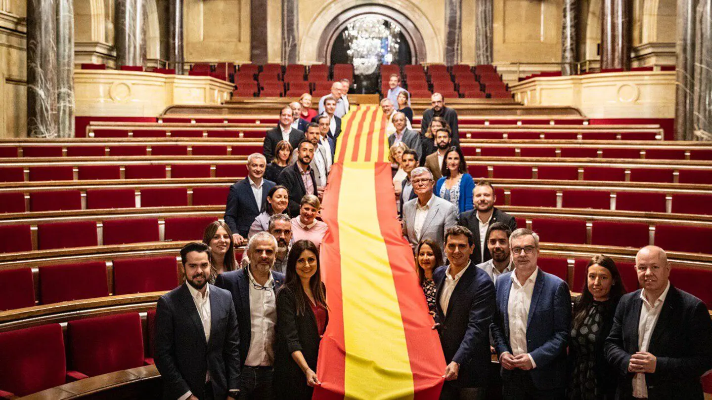 Los miembros de Cs sujetan una doble bandera de España y Cataluña en el Parlament Los miembros de Cs sujetan una doble bandera de España y Cataluña en el Parlament