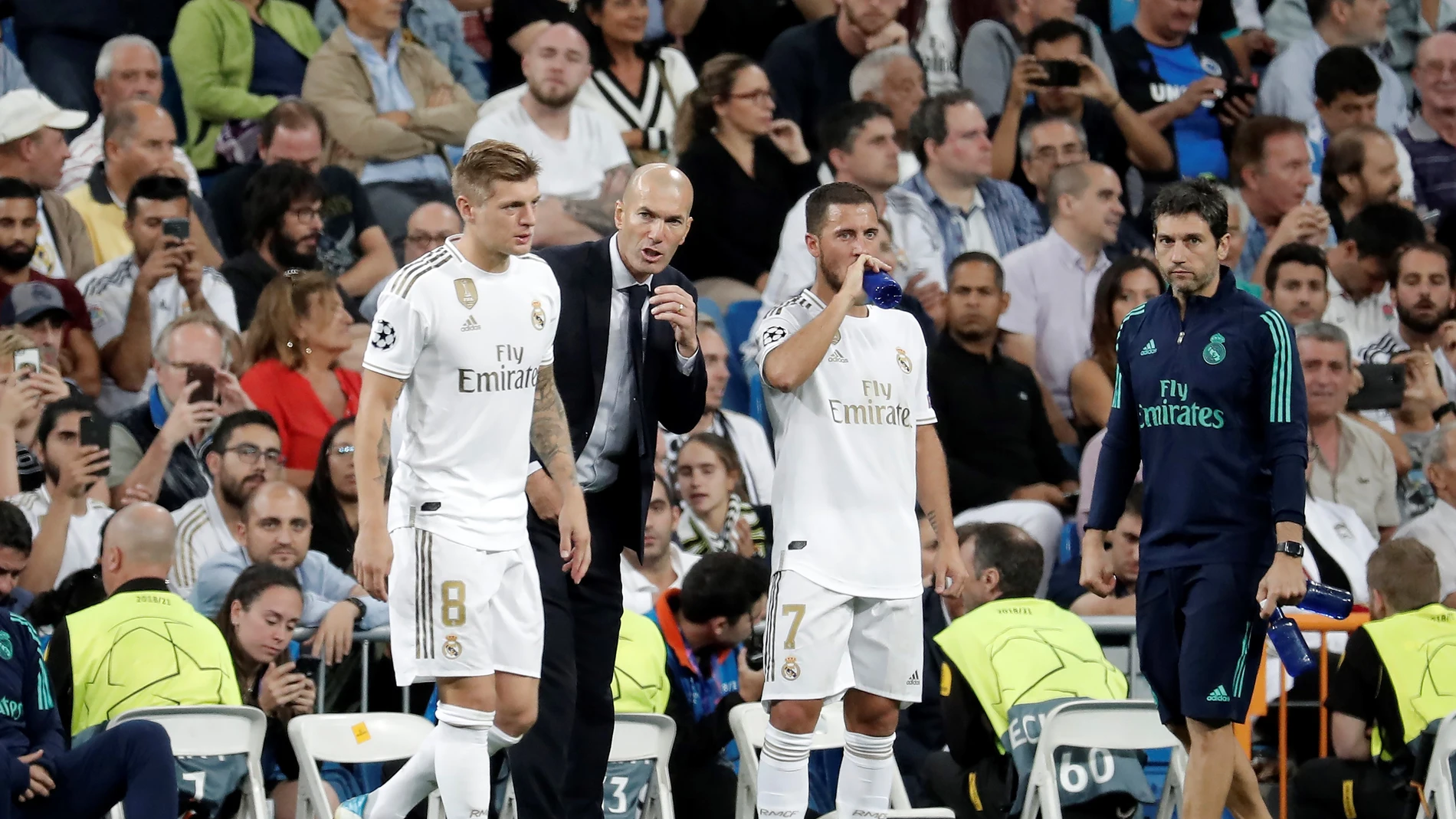 Zidane da instrucciones a Kroos y a Hazard en la banda del Bernabéu