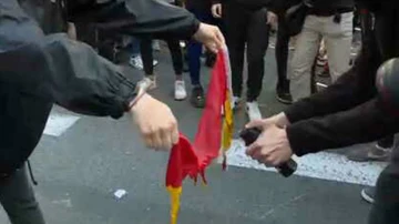 Dos jóvenes queman una bandera de España en la marcha de los estudiantes