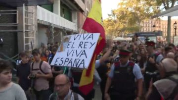 Los mossos escoltan a un ciudadano con la bandera de España en la manifestación de los estudiantes