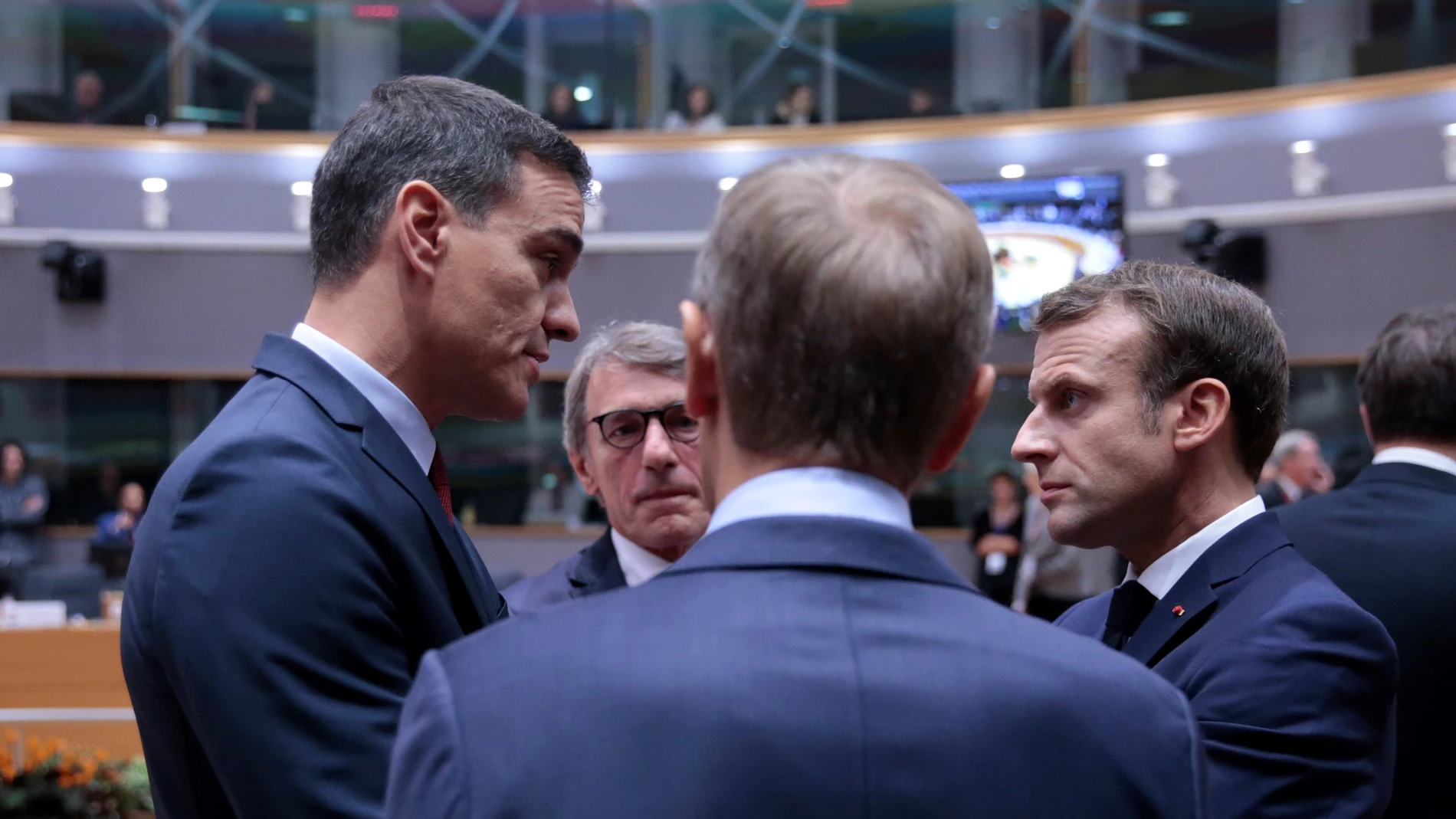 El presidente de España, Pedro Sánchez, conversa con su homólogo francés, Emmanuel Macro, frente a los presidentes del Parlamento Europeo, David Sassoli, y el Consejo Europeo, Donald Tusk