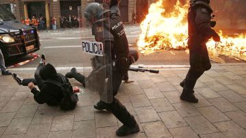 Policías antidisturbios y manifestantes durante los incidentes en Barcelona