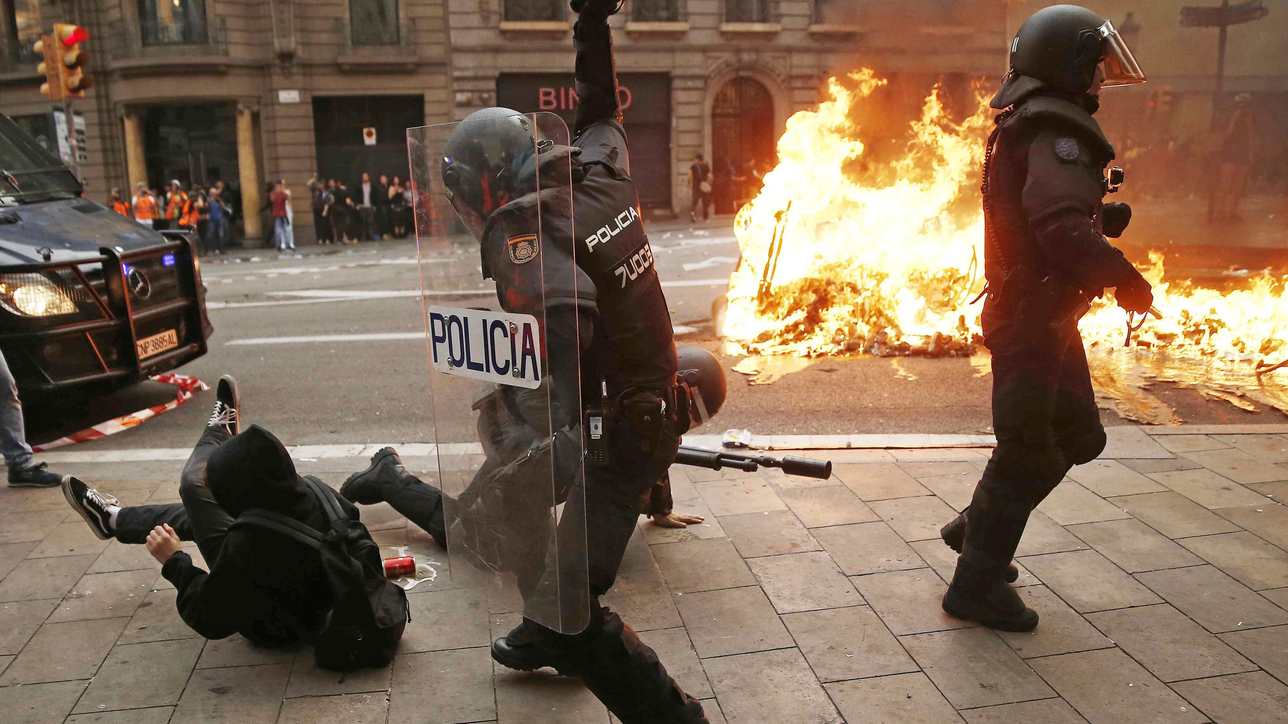 Policías antidisturbios y manifestantes durante los incidentes en Barcelona