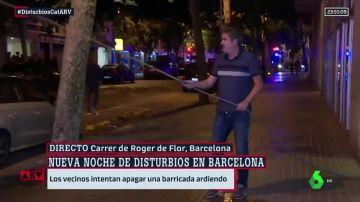 Un vecino intenta apagar el fuego de una barricada con su chándal